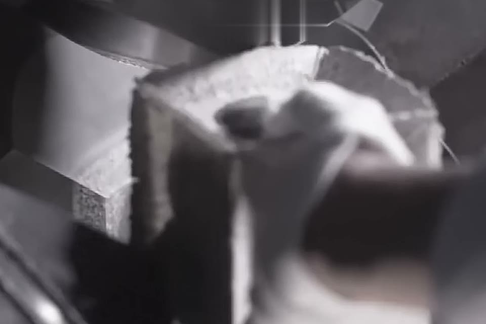 A gloved hand lifting the growth cell from the press