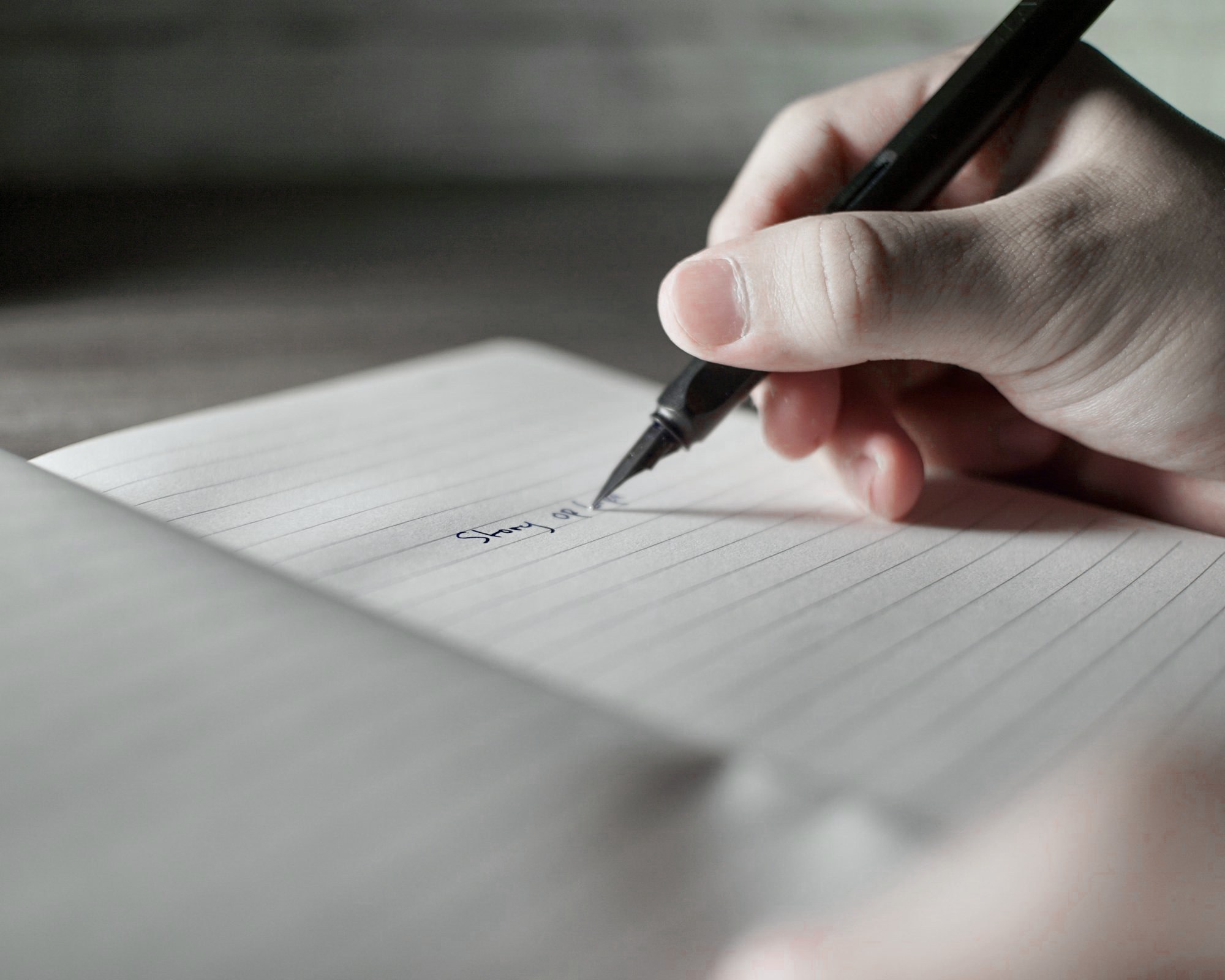 A hand writing the first words of a story with a fountain pen